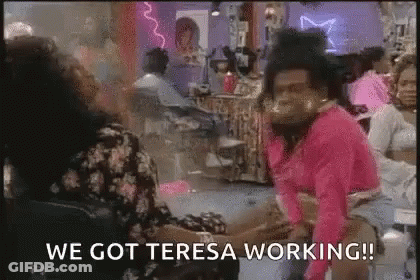 Man In Pink Shirt Sitting In Salon Talking To Woman GIF