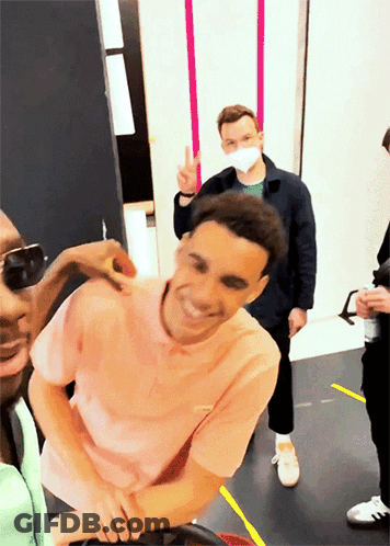 Man In Pink Shirt Smiling And Giving Peace Sign GIF
