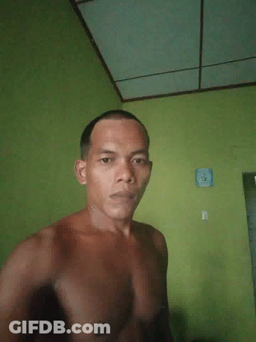 Man In Pink Shirt Standing In Front Of Pause Screen GIF