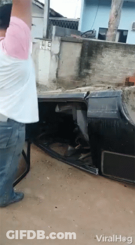 Man In Pink Shirt Standing Next To Crashed Car GIF