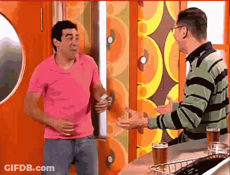 Man In Pink Shirt Talking To Man In Green And Black Striped Sweater GIF