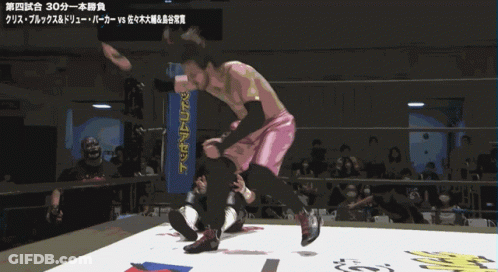 Man In Pink Shorts Kneeling In Front Of Blue Box Saying NM GIF