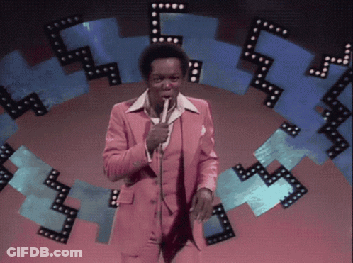 Man In Pink Suit Holding Microphone GIF