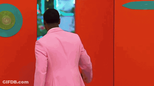 Man In Pink Suit In Doorway GIF