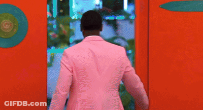 Man In Pink Suit Peeking Out Of Red Wall GIF