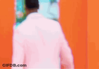 Man In Pink Suit Walking Through Door GIF