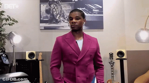 Man In Pink Suit With Guitars And Speakers And BET Logo GIF