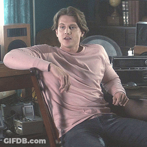 Man In Pink Sweater Sitting In Chair GIF
