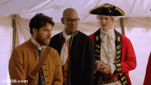Man In Pirate Hat Next To Historical Costumes GIF