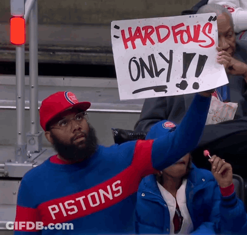 Man In Pistons Shirt Holding Sign GIF