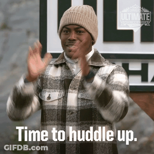Man In Plaid Jacket And Beanie Saying Huddle Up GIF