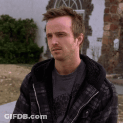 Man In Plaid Jacket And Gray Shirt Sitting Outside GIF