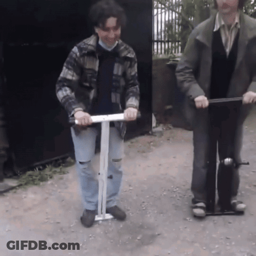 Man In Plaid Jacket Riding Scooter With Another Man GIF