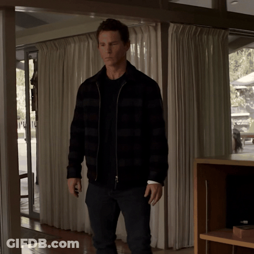 Man In Plaid Jacket Standing In Room With White Curtains GIF