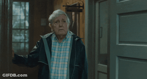 Man In Plaid Shirt And Black Jacket In Hallway GIF