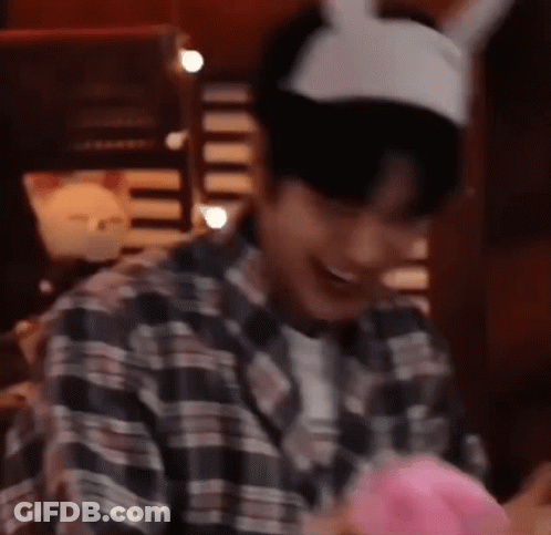 Man In Plaid Shirt And Bunny Ears Holding Pink Balloon GIF