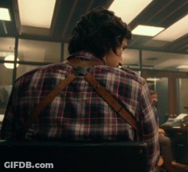 Man In Plaid Shirt And Suspenders Sitting In Chair GIF