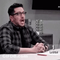 Man In Plaid Shirt And Tie Sitting With Hands Folded GIF