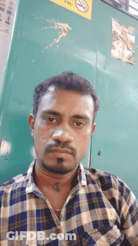 Man In Plaid Shirt By No Smoking Sign GIF