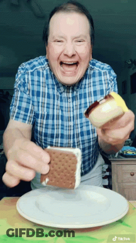 Man In Plaid Shirt Eating Ice Cream Sandwich On White Plate GIF