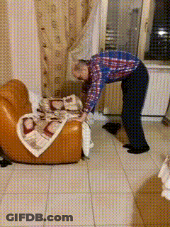 Man In Plaid Shirt Folding Blanket On Chair GIF