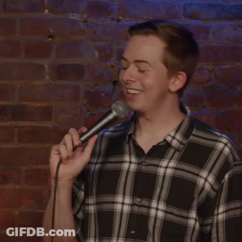 Man In Plaid Shirt Holding Microphone GIF