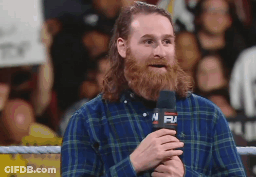 Man In Plaid Shirt Holding Microphone With NFM GIF