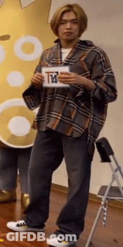 Man In Plaid Shirt Holding Sign With Letter T GIF