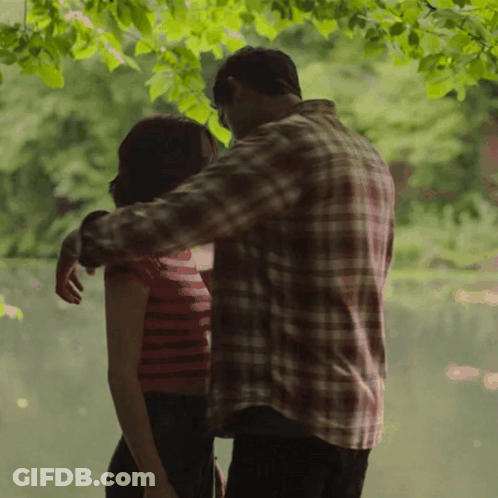 Man In Plaid Shirt Hugging Woman In Red Striped Top GIF