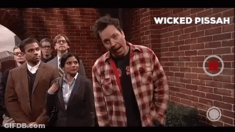 Man In Plaid Shirt In Front Of Brick Wall GIF