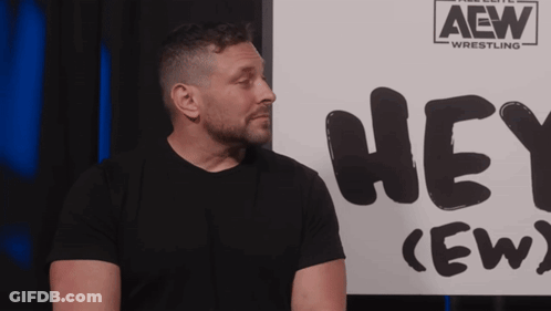 Man In Plaid Shirt In Front Of Hey Crew Sign GIF