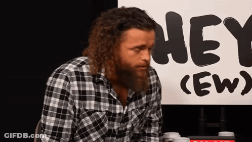 Man In Plaid Shirt In Front Of Hey Ew Sign GIF