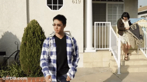 Man In Plaid Shirt In Front Of House Number 619 GIF