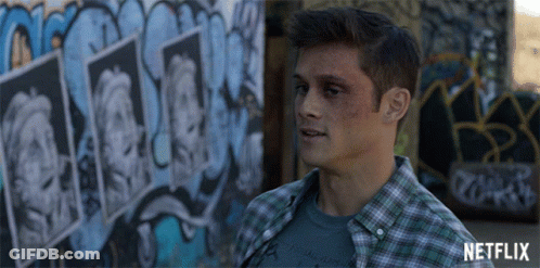 Man In Plaid Shirt In Front Of Netflix Graffiti GIF