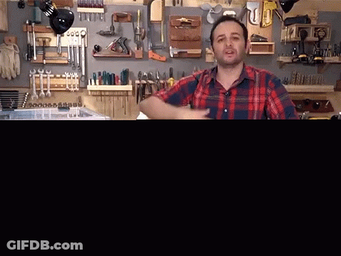 Man In Plaid Shirt In Front Of Tools GIF