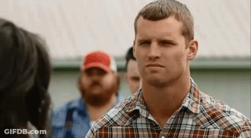 Man In Plaid Shirt Looking At Woman In Red Hat GIF