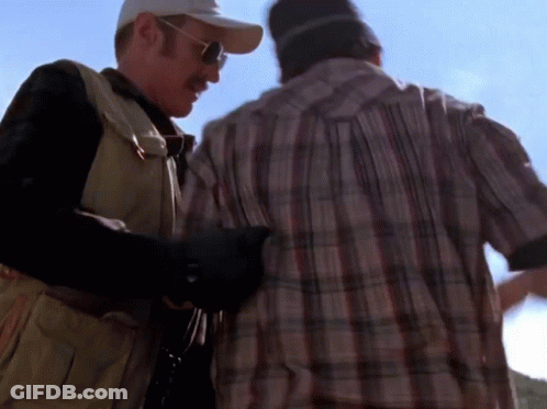 Man In Plaid Shirt Next To Man In Baseball Cap GIF