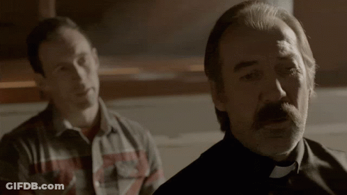 Man In Plaid Shirt Next To Man In Black GIF