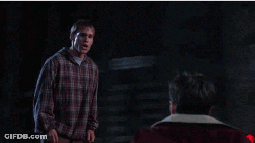 Man In Plaid Shirt Next To Man In Red Jacket GIF