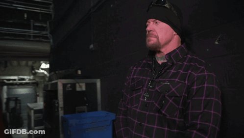 Man In Plaid Shirt Next To Man GIF