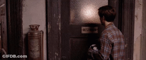 Man In Plaid Shirt Opening Restroom Door GIF