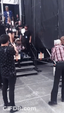 Man In Plaid Shirt Photographing Woman On Stairs GIF