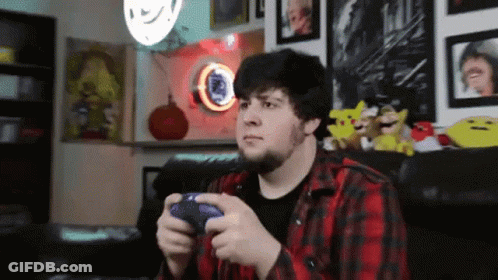 Man In Plaid Shirt Playing Video Game With PlayStation Controller GIF