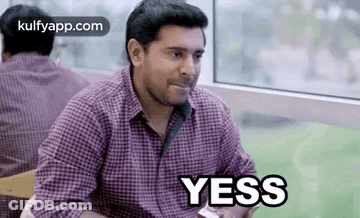 Man In Plaid Shirt Saying Yes At Table GIF
