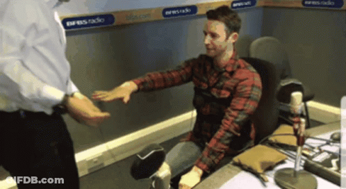Man In Plaid Shirt Shaking Hands In Front Of Express Radio Sign GIF