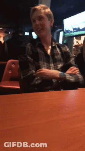 Man In Plaid Shirt Sitting At Table GIF