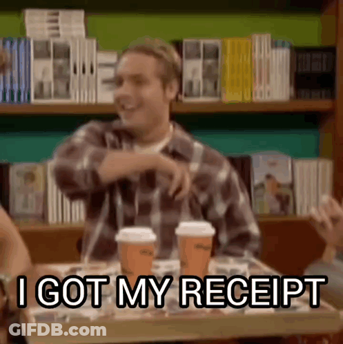 Man In Plaid Shirt Sitting At Table With Two Coffee Cups GIF