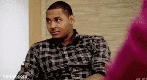 Man In Plaid Shirt Sitting In Chair Looking At Something GIF
