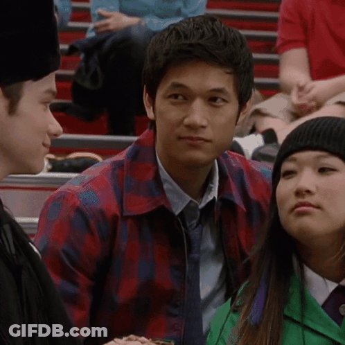 Man In Plaid Shirt Sitting In Crowd GIF