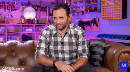 Man In Plaid Shirt Sitting On Couch With Blue M GIF